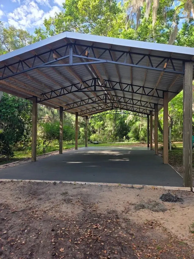 Open-sided metal-roof pole barn on a concrete slab in Central Florida