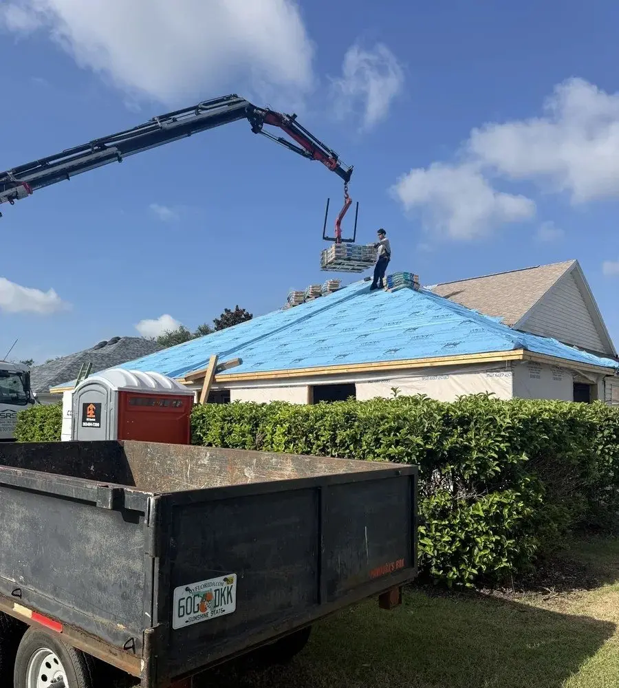 Roof dried in with synthetic underlayment on a home in The Villages, FL, with a dump trailer staged in the yard