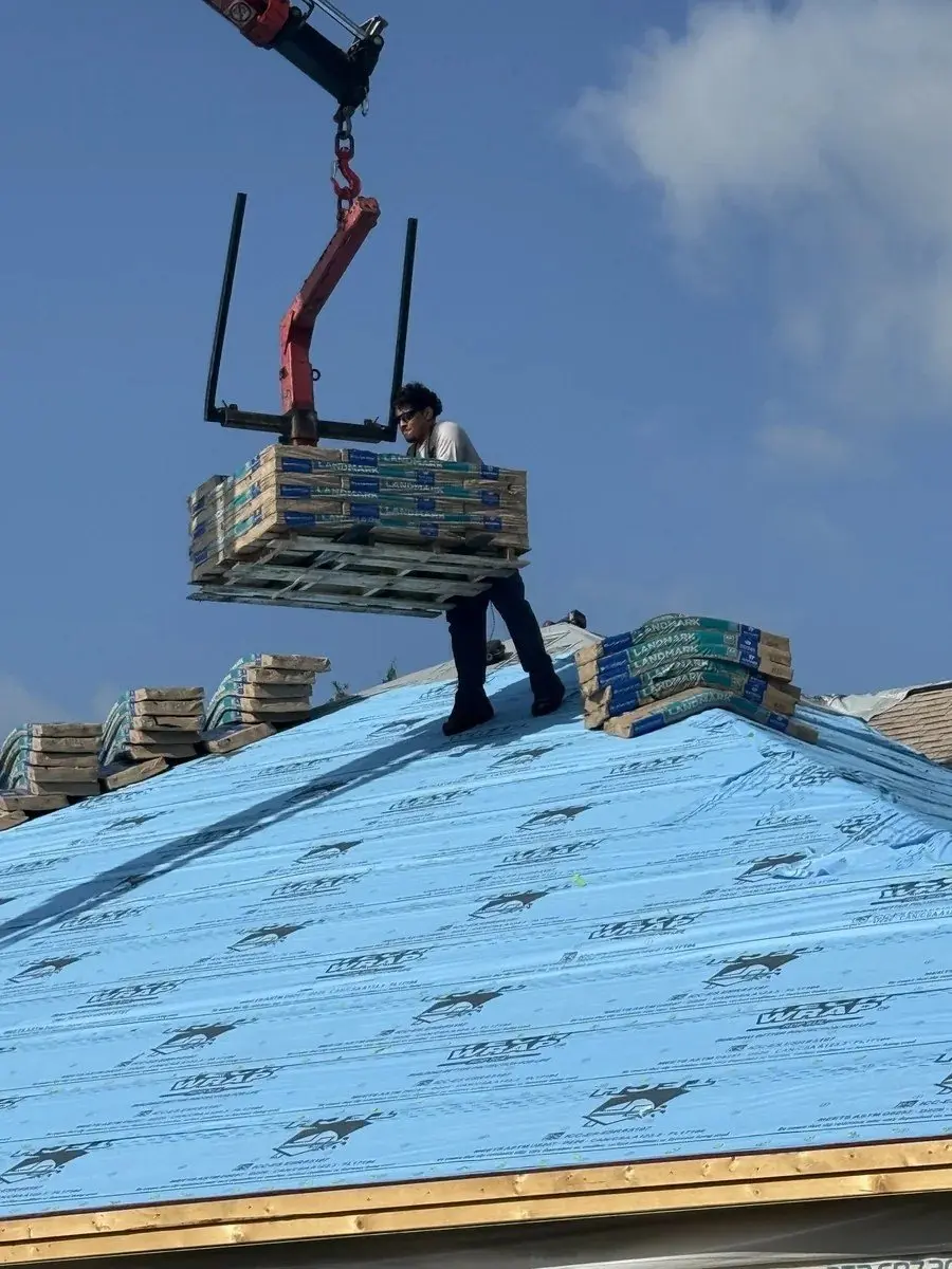Crane lifting bundled shingles onto a dried-in roof deck in The Villages, FL